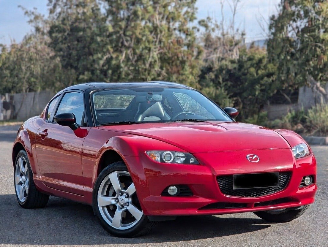 "Red Mazda MX-5 Miata convertible parked on road – great beginner track day car in 2026 with lightweight design and fun handling"